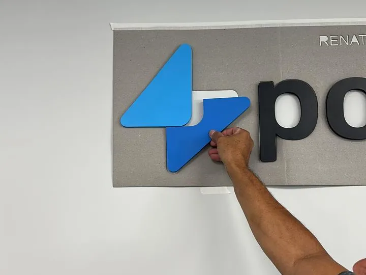 Instalador fixando o logotipo powercrm na parede