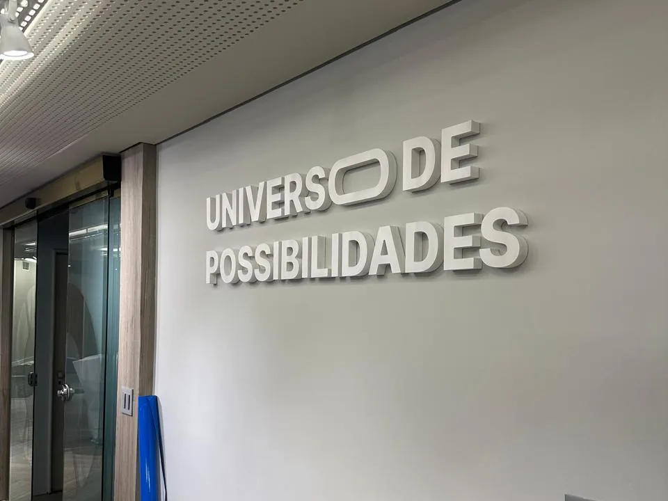 Frase Universo de Possibilidades em letras caixa na parede do corredor